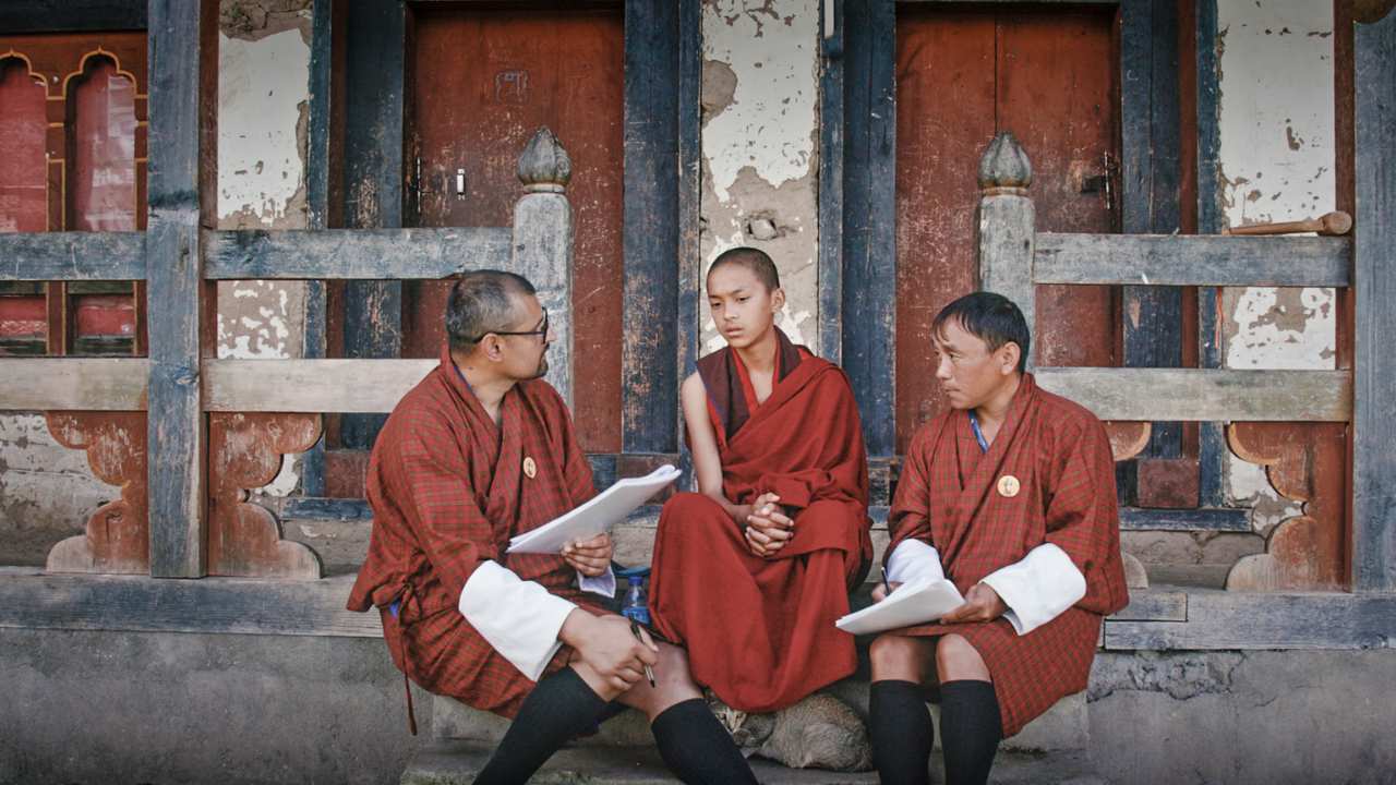 three people in red sitting on steps